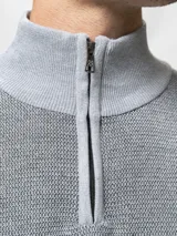 Sweater de tejido de punto con textura tipo waffle, color azul marino, con cuello alto y cierre frontal parcial. Cuenta con puños y ruedo acanalados.