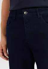 Pantalón de jean azul oscuro, de corte recto, con bolsillos laterales y traseros. Se ajusta a la cintura con botón y cierre. Fabricado en denim con elastano.
