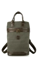 Mochila matera de diseño vertical, confeccionada en tela canvas marrón con detalles y refuerzos en cuero sintético oscuro. Cuenta con doble asa superior de mano, correas traseras regulables, cierre metálico frontal y bolsillo posterior.