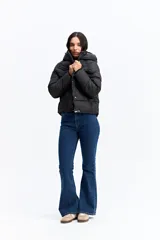 Campera puffer negra con capucha, diseño corto y acolchado, cierre frontal con botones a presión y puños ajustados.