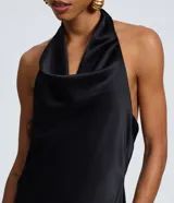 Vestido midi de satén color negro, con escote degagê drapeado y espalda abierta con tiras ajustables. Presenta un corte fluido y elegante.