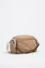 Bolso tipo morral Bimba y Lola, de color tostado, confeccionado en nylon suave con detalles en cuero y tirantes de cordón. Cuenta con múltiples compartimentos con cierre y el logo metálico de la marca en el frente.