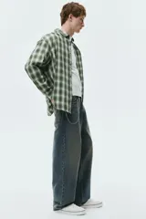 Jean de corte baggy en denim de algodón rígido, color azul con efecto deslavado y acabado vintage. Diseño de cinco bolsillos, tiro bajo y piernas amplias redondeadas.