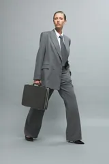 Pantalón de vestir gris con finas rayas verticales, corte sastrero y pierna ancha.