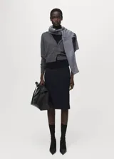 Cardigan de punto fino con cuello en pico y cierre frontal de botones. Presenta un diseño recto de manga larga, confeccionado en lana.