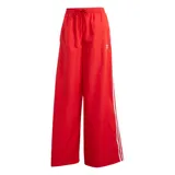 Pantalon Adidas de corte ancho y tiro alto, color rojo, con cintura elástica ajustable mediante cordón. Presenta las icónicas tres tiras blancas laterales y el logo del trébol bordado en la parte superior.