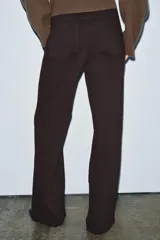 Jeans de tiro alto con corte wide leg y largo completo. Presenta diseño de cinco bolsillos, trabillas en la cintura y cierre frontal con cremallera y botón, con un acabado de efecto lavado.