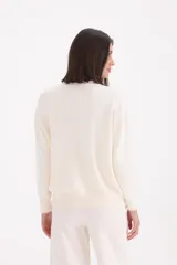 Sweater básico de tejido de punto, con cuello redondo, manga larga y puños y ruedo acanalados.