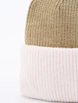 Gorro de lana tejido con diseño de bloques de color, combinando una parte superior en fucsia y un borde inferior dividido en lila y bordó.