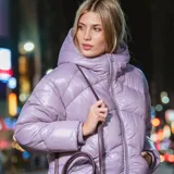 Campera puffer lila, acolchada y liviana, con capucha, cierre frontal, puños elásticos y dos bolsillos con cierre.