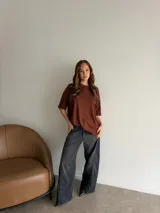 Jean ancho gris oscuro con efecto gastado, tiro alto y corte recto de perneras amplias.