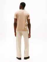 Remera color beige de algodón, de corte regular, con cuello redondo y bolsillo de parche en el pecho con logo de la marca.