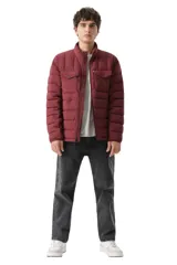 Campera puffer acolchada color bordó, con cierre frontal, cuello alto y dos bolsillos frontales con solapa y botón a presión.