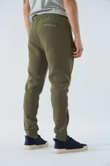 Pantalón de felpa gris para hombre con logo estampado y en goma, bolsillos con cierre, cierres en los tobillos, cintura ajustable y puños.