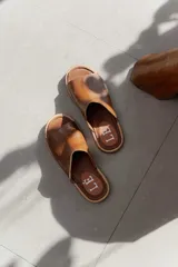 Sandalia tipo chinela de cuero marrón con textura granulada, plantilla de cuero y suela de madera con base de goma.