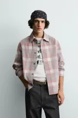 Camisa de corte relajado confeccionada en pana de algodón con diseño de cuadros. Presenta cuello solapa, cierre frontal de botones y mangas largas con puños abotonados.