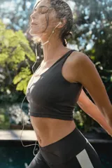 Top deportivo de escote redondo y espalda estilo nadador, confeccionado en tejido técnico elástico. Presenta un diseño ajustado al cuerpo con pretina ancha para mayor soporte.