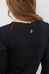 Remera de manga larga con escote en V, confeccionada en algodón de doble capa con textura suave y ajuste al cuerpo.