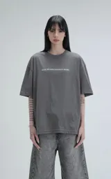 Remera unisex de corte oversize y hombros caídos, color gris concreto. Presenta cuello redondo acanalado y estampa frontal con la frase 'Que no entiendan nada' en color blanco.