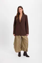 Blazer de corte sastrero en color marrón chocolate, con solapas clásicas, cierre frontal de un botón y bolsillos laterales con solapa.