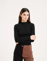 Polera negra de tejido de punto acanalado, con cuello alto y mangas largas.