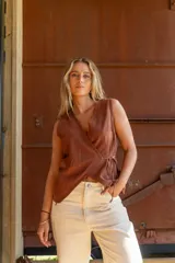 Blusa marrón cruzada de tusor, con escote en V y lazo interno para ajustar.