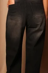 Pantalón de jean negro con efecto desgastado, corte recto y bolsillos cuadrados en la parte trasera.