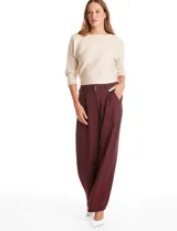 Pantalón tipo palazzo de corte ancho y fluido, confeccionado en tejido sastrero. Presenta tiro alto con doble abotonadura frontal, pinzas decorativas y cintura elástica en la parte posterior. Incluye bolsillos laterales funcionales.