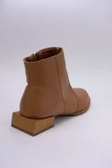 Botín de cuero dorado con punta fina y taco bajo cuadrado de madera.