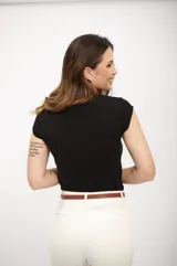 Remera negra de algodón con cuello en V y mangas cortas con volados. Corte clásico.