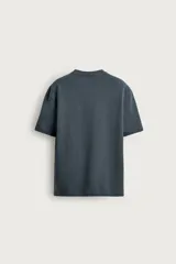Remera blanca de corte relajado, con cuello redondo y mangas cortas.
