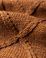 Buzo de lana merino color marrón con diseño de tejido trenzado en el frente y cuello redondo acanalado. Presenta puños y ruedo elásticos, con una pequeña etiqueta decorativa en la parte inferior.