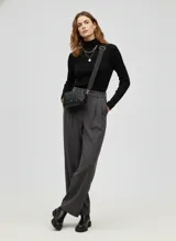 Cartera bandolera negra de efecto cuero, con diseño acolchado de rombos y correa ancha ajustable. Cuenta con herrajes metálicos color dorado claro y cierre de cremallera.