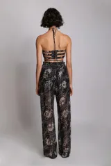 Pantalón palazzo de tiro alto con cintura elástica y cordones ajustables. Estampado floral en tonos blanco y negro.