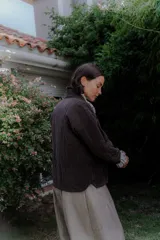 Chaqueta acolchada de algodón en color crudo, con diseño de matelassé, corte holgado, mangas largas y bolsillos frontales tipo parche.