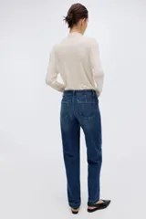Jean de denim color azul oscuro, con corte wide leg de tiro alto, bolsillos delanteros de parche y pliegues marcados al frente.