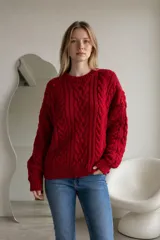 Sweater de punto grueso color rojo, con diseño de trenzas verticales, cuello redondo y puños acanalados.
