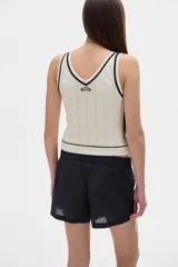 Musculosa tejida color borgoña con cuello en V y ribete amarillo.