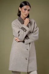 Tapado de corte recto con estampado de pata de gallo en tonos azul y gris. Presenta cuello camisero y detalles en los puños en color negro, cierre frontal con botones y bolsillos laterales.