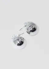 Par de aros plateados con forma de gota y strass incrustados.