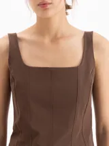 Top negro de inspiración corset confeccionado en poliamida y elastano, con escote cuadrado, breteles anchos, recortes frontales que entallan el busto, escote profundo en la espalda, ruedo semicurvo y cierre metálico en la parte posterior.