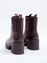 Bota de caña corta color negro, de símil cuero, con plataforma de 7 cm de alto. Cuenta con cierre y pieza de textura croco en laterales.