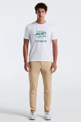 Remera blanca de manga corta y cuello redondo, con estampado gráfico en verde en el centro del pecho que incluye ilustraciones de vasos, naipes y dados junto al texto "BOTTOMS UP!".