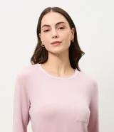Pijama de dos piezas compuesto por una blusa de manga larga con cuello redondo y bolsillo frontal, y un pantalón recto con cintura elástica. Ambas prendas presentan detalles de piping en los bordes. Confeccionado en tejido de viscolycra suave y fluido.