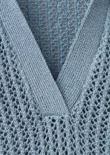 Chaleco de punto celeste, con detalles bordados calados, cuello polo y diseño recto sin mangas.