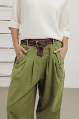 Pantalon de corte amplio y relajado en color verde, con pinzas delanteras, botones decorativos y cinturón de lona incluido.