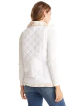 Chaleco reversible marca Weekend Routine, con un lado de piel sintética suave en tonos beige y blanco, y el otro lado capitoneado en blanco con diseño de rombos. Cuenta con cuello alto, bolsillos delanteros y cierre metálico dorado.