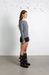 Botas de caña media en cuero negro, con diseño holgado y tres correas horizontales con hebillas metálicas ajustables. Poseen taco cuadrado bajo y punta redondeada.