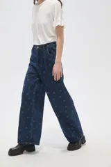 Pantalón de jean azul oscuro de corte ancho, con tiro alto, pinzas frontales y estampado de lunares.