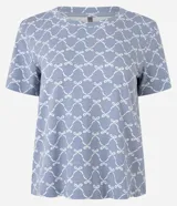 Blusa de pijama de viscosa con estampado de lacitos blancos sobre fondo azul. Presenta cuello redondo y mangas cortas, con un corte holgado y cómodo.